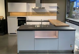 Weiße Inselküche mit integrierter Sitzgelegenheit